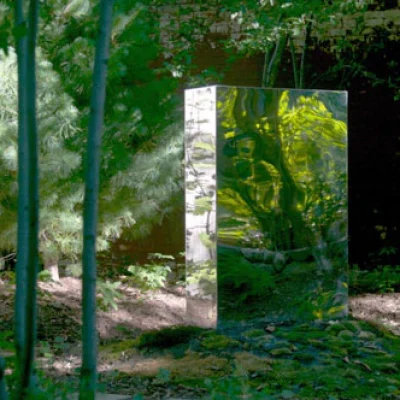 A mirrored sculpture reflecting a tree